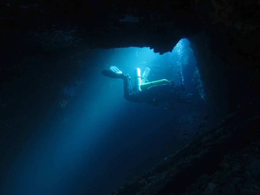 diver swimming into amfitriti cave